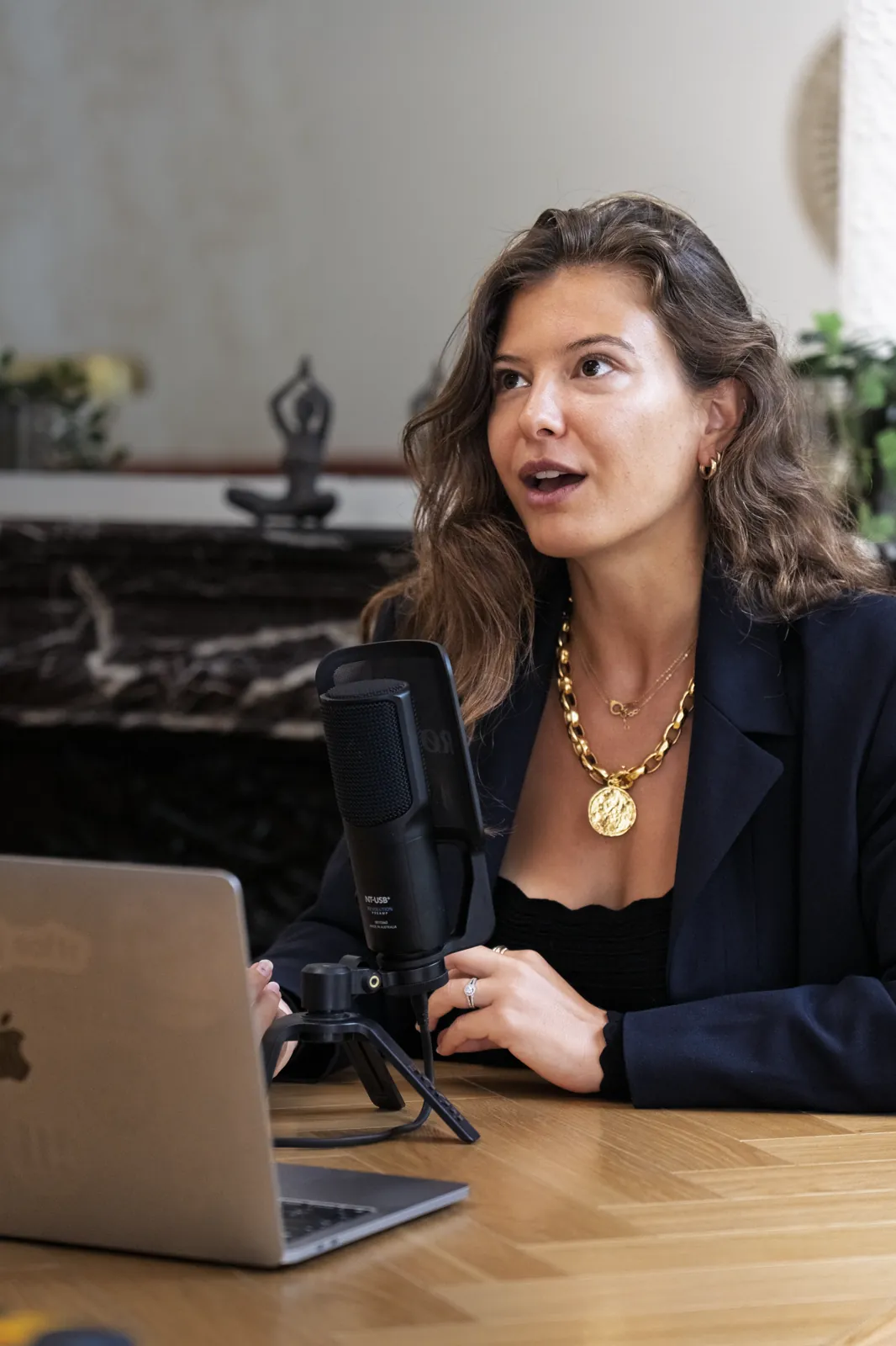 At a podcast microphone, laptop open, mid-conversation, portrait session in Paris